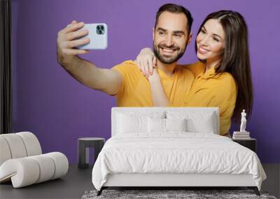 Young couple two friends family man woman together in yellow casual clothes doing selfie shot on mobile cell phone post photo on social network hug isolated on plain violet background studio portrait. Wall mural