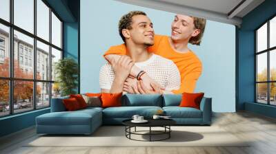 Young couple two gay men wear casual clothes together hugging cuddle look to each other isolated on pastel plain light blue color background studio portrait. Pride day june month love LGBTQ concept. Wall mural