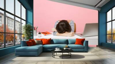 Young Disappointed Tired woman laid her head down on the table sit, work at white desk with contemporary pc laptop isolated on pastel pink background. Achievement business career concept. Copy space. Wall mural