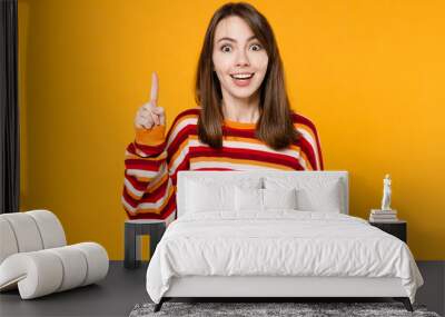 Young insighted smart proactive caucasian woman 20s in red striped sweatshirt hold index finger up with great new idea isolated on plain yellow background studio portrait. People lifestyle concept Wall mural