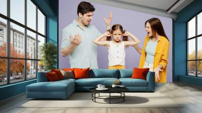 Young sad parents mom dad with child kid girl 6 years old wear blue yellow casual clothes cover ear with hands fingers do not want listen scream isolated on plain purple background Family day concept Wall mural