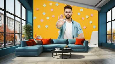 Young serious strict employee business man in shirt sit work at white office desk with pc laptop do stop palm gesture refusing say no isolated on yellow background studio portrait Achievement concept. Wall mural