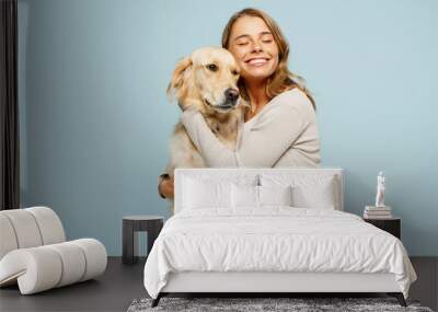 Young smiling cheerful fun owner woman with her best friend retriever wear casual clothes hug embrace dog close eyes isolated on plain pastel light blue background studio. Take care about pet concept Wall mural