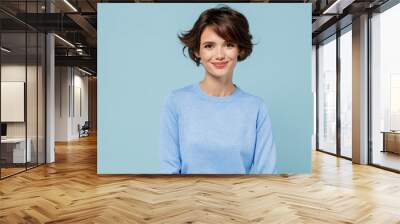 Young smiling fun happy caucasian european attractive cute woman 20s in casual sweater looking camera isolated on plain pastel light blue color background studio portrait. People lifestyle concept Wall mural