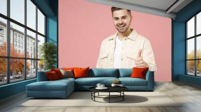 Young smiling happy positive satisfied trendy fashionable caucasian man in jacket white t-shirt show thumb up like gesture isolated on pastel pink background studio portrait. People lifestyle concept. Wall mural