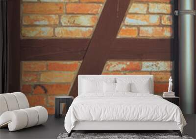 old brick wall with wooden elements. warm colors from sunlight. rough texture of old bricks connecte Wall mural