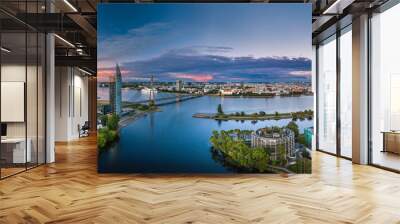 Riga city panorama with colorful sunset in the sky. Modern architecture meets old town. Picturesque view over riverside.  Wall mural