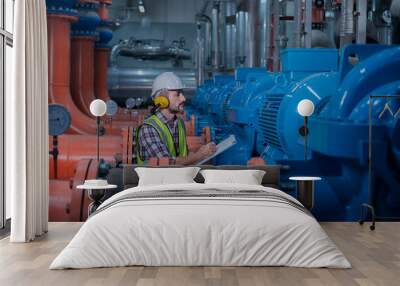 Mechanical engineer Checking of centrifugal pump in pump room. worker working in plant room. Industry engineer under checking the industry  air conditioner is water chiller plant. Wall mural