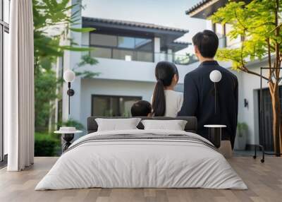 Back view of Asian family standing in front of their new house Wall mural