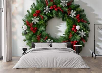 Christmas wreath with red berries and golden balls on a white wall Wall mural