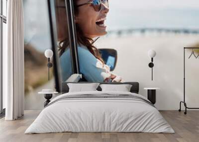 Happy, freedom and road trip with a woman in a car, looking at the view from the window while on the open road. Smile, travel and fun with a young female traveler on a journey during her vacation Wall mural