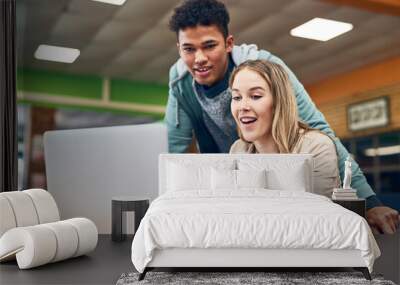 Heres all the information at out fingertips. Shot of a young man looking on while a female student works on a laptop. Wall mural