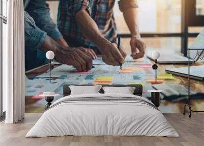 A group of people collaborating on a project, with laptops and papers spread out Wall mural