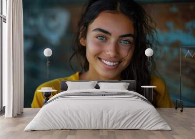 A happy woman wearing a bright yellow shirt smiling directly at the camera Wall mural