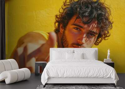 A person with curly hair wearing a bright yellow shirt, potentially suitable for use in lifestyle or advertising contexts Wall mural