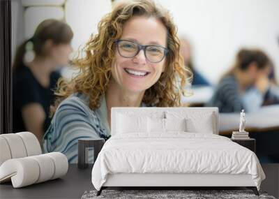 A teacher sits at her desk in a classroom Wall mural