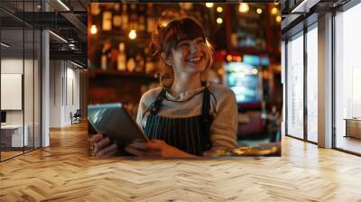 A woman sits at a bar using a tablet computer, possibly working or browsing Wall mural