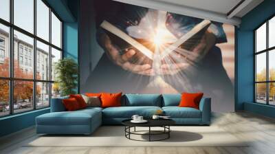 The light coming from the book in the hand of man concept wisdom religion reading imagination. Wall mural