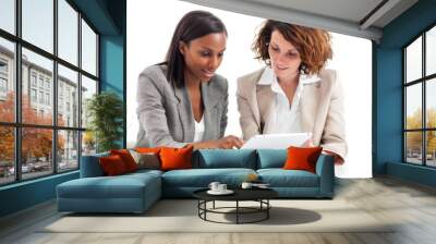 Two females examining digital device Wall mural