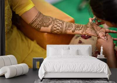 View of a woman drawing traditional Henna Mehandi body art on a hand Wall mural