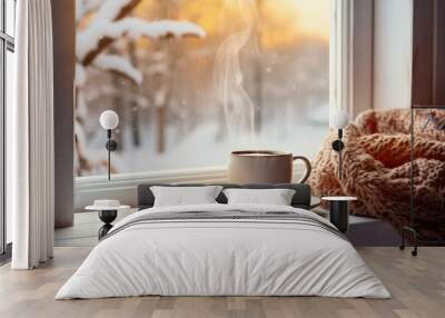 A cup of tea, a book and a warm knitted blanket on the windowsill, close-up. Winter outside, cozy room Wall mural