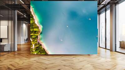 Boats from the air. Aerial view of a lake in Italy. Summer landscape with clear water on a sunny day. Top view of the boat from a drone. The clouds are reflected in the water Wall mural