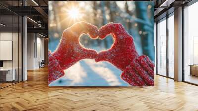 Gloves on a woman's hands with a heart symbol against a sunset background. Wall mural