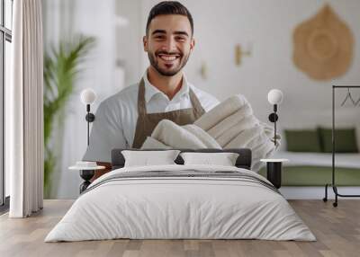 Male housekeeper holding clean towels.  Wall mural