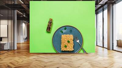 Raw instant noodles on a plate and on a colored background. Top view with space for text. Wall mural