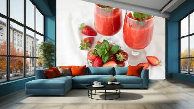 Two glasses of fresh strawberry smoothie and a bowl of ripe strawberries on the white background. Wall mural