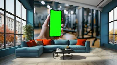 Hand holding smartphone with fitness app mockup, online workout training concept, modern mobile technology for remote gym exercise Wall mural