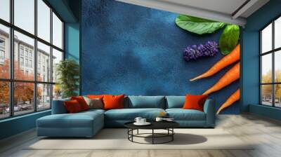  A collection of carrots atop a blue backdrop, adjacent to purple blossoms and a verdant, leafy plant Wall mural