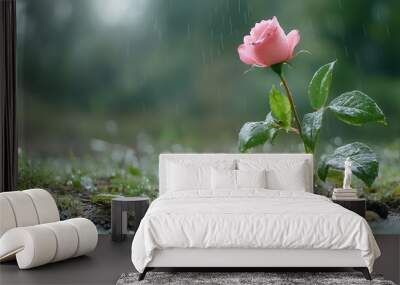  A pink rose atop moss-covered ground, near a rain-filled puddle Wall mural