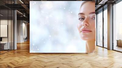  A stunning woman poses by the window as snowfall gently dusts her face; her hair neatly tied in a bun Wall mural