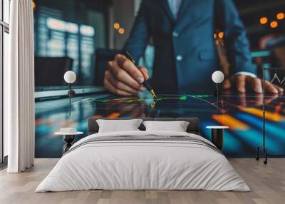  A tight shot of someone scribbling on a paper with a pen, a laptop visible behind Wall mural