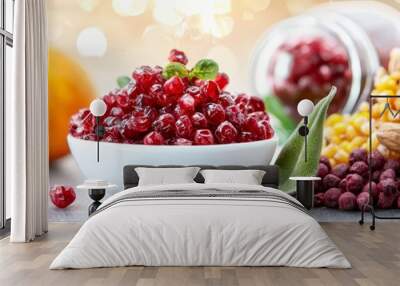  A white bowl holds cranberry sauce Nearby, a pile combines cranberries, corn, and oranges Wall mural