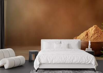  A wooden bowl filled with powder sits next to a whisk and a sprig of rosemary on the table Wall mural