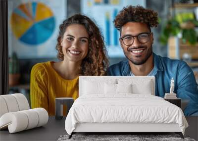 A man and a woman smile at the camera, working together in an office setting Wall mural