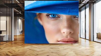 blue eyes beneath a blue hat atop her head Wall mural