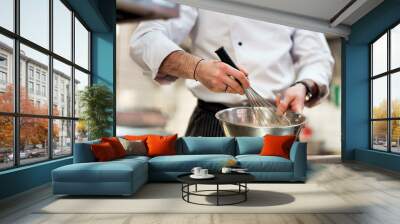 Chef in hotel or restaurant kitchen cooking, only hands. He is whisking ingredients. Wall mural