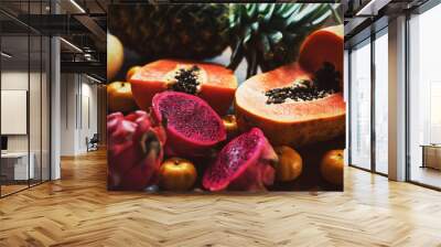 Juicy exotic fruits close up. Pineapple, papaya, mango, gragon fruit on table ready to eat Wall mural