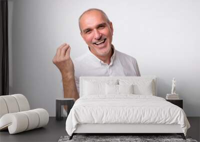 Portrait of mature handsome man in white shirt showing italian gesture that means what do you want over white background. Bald gloomy guy do not have clue of what happening Wall mural