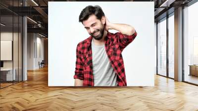 Shy guy tries to ask lovely woman for date. Portrait of happy charming young male with bristle holding hand on back of head and smiling. Feeling awkward and embarrassed. Wall mural