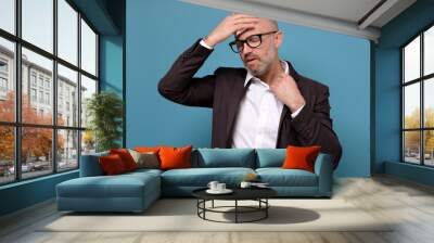 Sweating mature italian businessman in suit and glasses wiping sweat from head with napkin. Wall mural