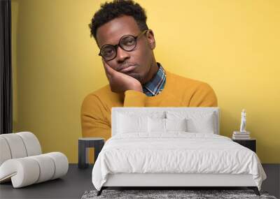 Unhappy frustrated young african man having puzzled expression Wall mural