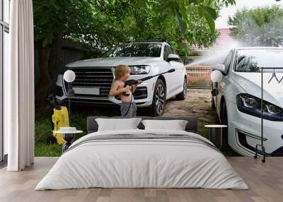 Little boy playing washes the car. Wall mural