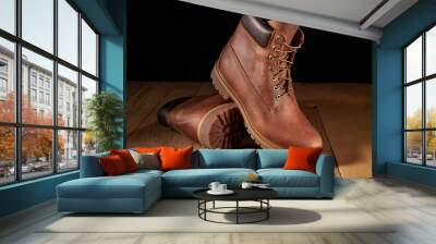 Pair of men leather brown waterproof boots for winter or autumn hiking on wooden table. Mens fashion, trendy footwear. Wall mural