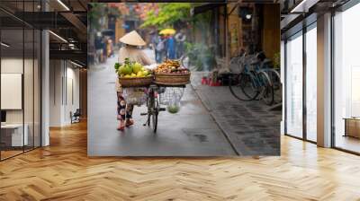 Woman walking in Hoi An with fruits Wall mural