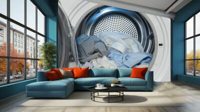 Close up view on clothes dryer machine with washed and dried shirts. Wall mural