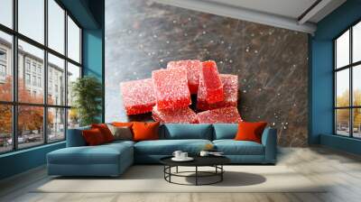 Strawberry pate de fruit (jelly, marmalade, fruit candy) covered with sugar on a dark background, back view Wall mural